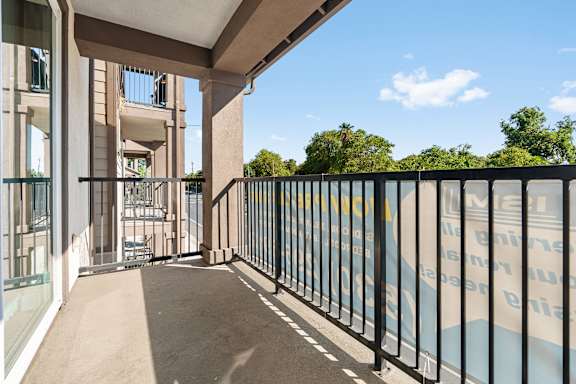 Balcony off of the living room. Concrete floor and vertical railings around balcony.