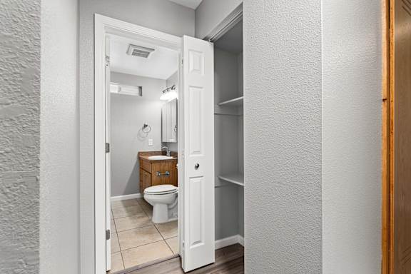 Bathroom with closet storage and wood vanity at OSM Properties Homes & Apartments, Chico, CA 95926