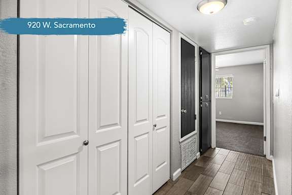 Hallway with white storage doors and wood flooring at OSM Properties Homes & Apartments, Chico, California