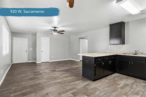 Open kitchen and dining space with dark cabinetry at OSM Properties Homes & Apartments, California