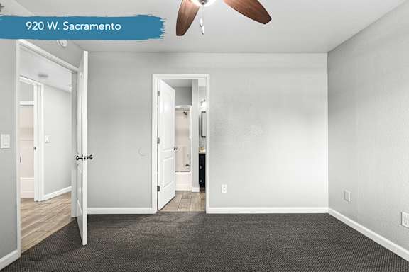 Empty bedroom with ceiling fan and bathroom access at OSM Properties Homes & Apartments, Chico, 95926