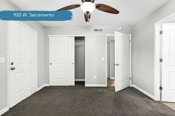 Bedroom with sliding closet and ceiling fan at OSM Properties Homes & Apartments, Chico, California