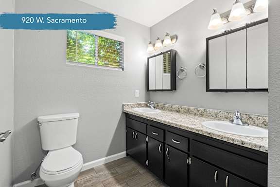 Modern bathroom with dual vanity and granite countertop at OSM Properties Homes & Apartments, California