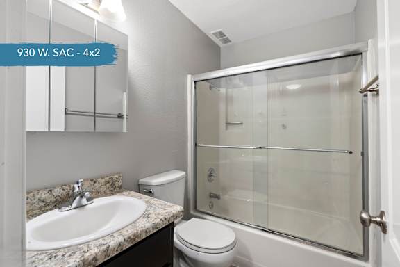 A bathroom with a toilet, sink, and shower.