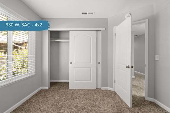 A room with a white door and carpeted floor.