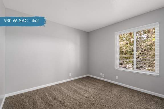 A room with a window and carpeted floor.