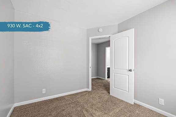 A room with a carpeted floor and a white door.