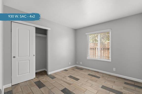 A room with a door and a window with blinds.