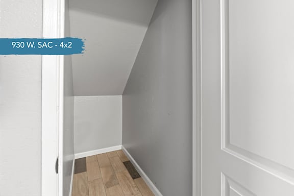 A hallway with a wooden floor and white walls.