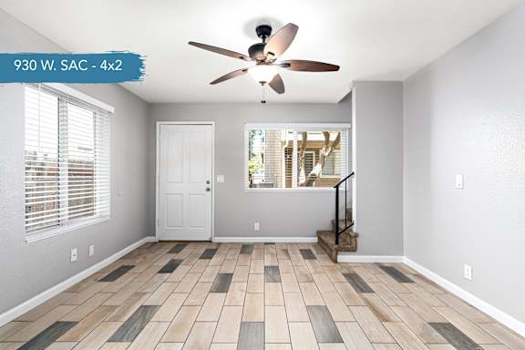 A room with a ceiling fan and a door.