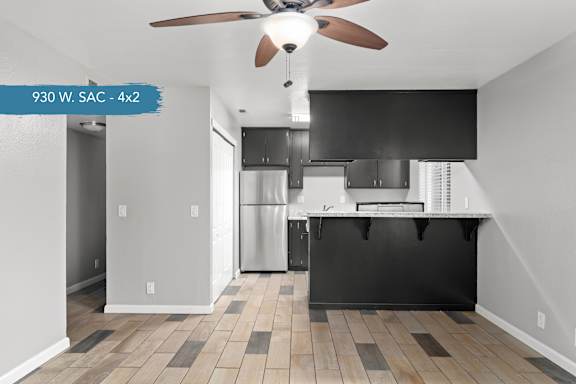 A kitchen with a fan and a black counter.
