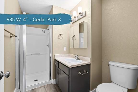 A bathroom with a toilet, sink, and shower.