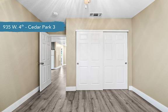 A hallway with a white door and a sign that says "935 W. 4th - Cedar Park 3".