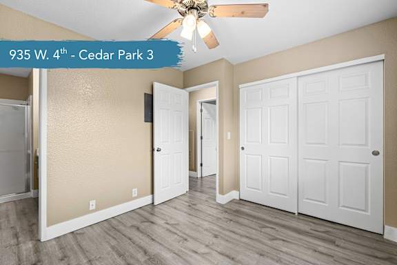A room with a ceiling fan and two doors.
