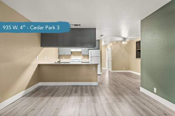 A spacious room with a television and a countertop at 935 W. 4th - Cedar Park 3.