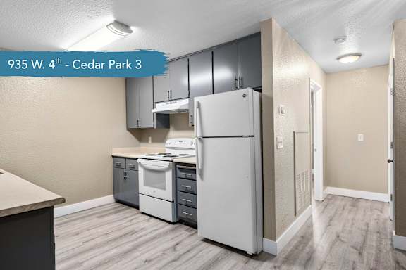 A kitchen with a white refrigerator and a white stove top oven.