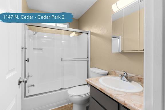 A bathroom with a toilet, sink, and shower.