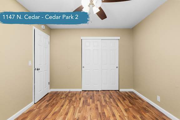 A room with two white doors and a ceiling fan.
