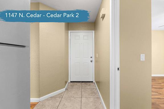 A room with a white door and a light switch on the wall.