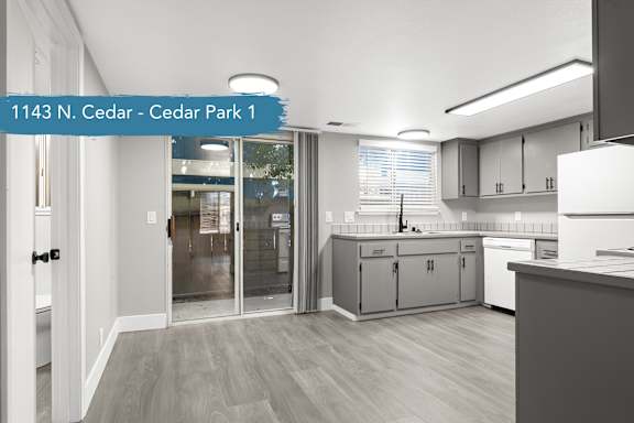 A modern kitchen with a white fridge and cabinets.
