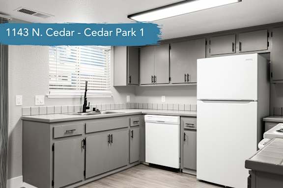 A kitchen with white appliances and grey cabinets.