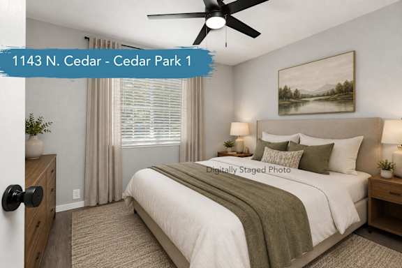 A bedroom with a bed, nightstand, and a painting on the wall.