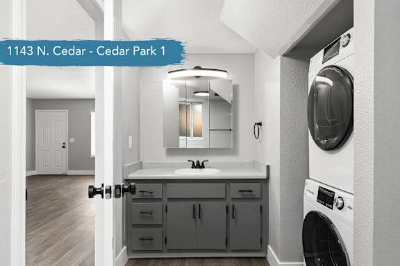 A modern laundry room with a washer and dryer built into the wall.