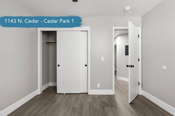 A white door is open in a room with wood flooring.