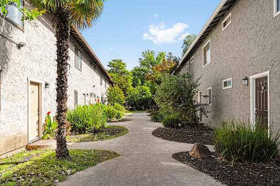 Walkway between residential buildings with landscaping at Cedar Park Apartments, California