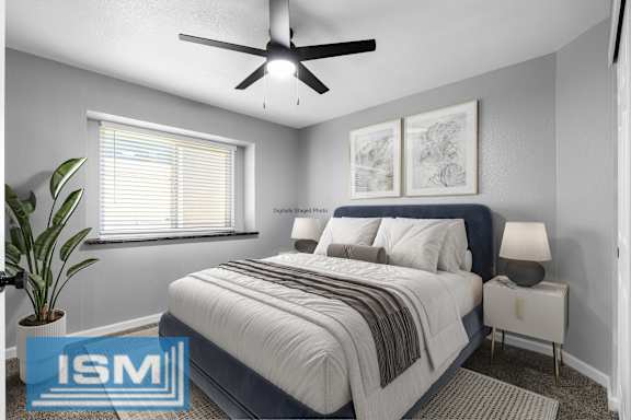 Digitally staged bedroom with navy bed and artwork at Redwood Cove Apartments, Chico, 95928