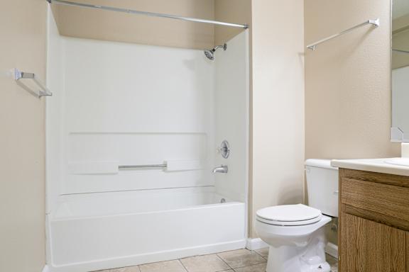 White tub with shower surround and chrome fixtures at Redwood Cove Apartments, California