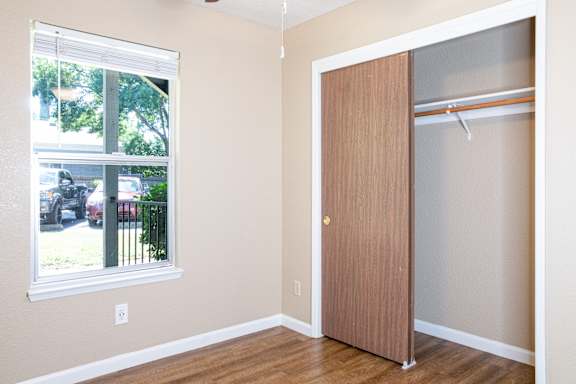 Bedroom with open closet and wood flooring at Redwood Cove Apartments, California, 95928