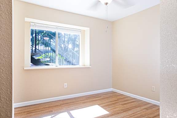 Empty bedroom with window overlooking outdoor balcony at Redwood Cove Apartments, Chico, CA 95928