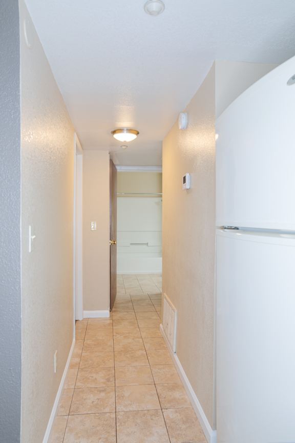 Hallway with tile flooring and ceiling lighting at Redwood Cove Apartments, Chico, CA