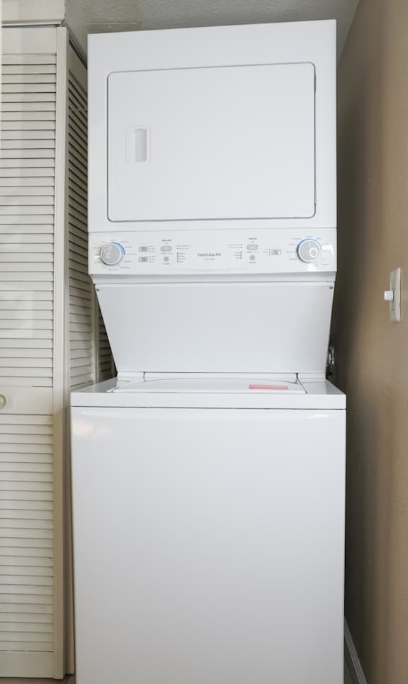 Stacked washer and dryer unit in laundry space at Redwood Cove Apartments, Chico, California
