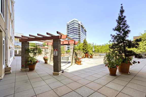 A patio with a red awning and potted plants.