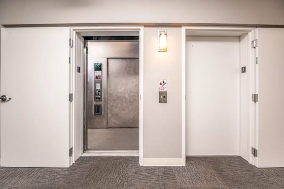 A white door with a silver elevator in the background.