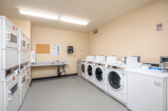 A laundry room with washing machines and a sign on the wall.