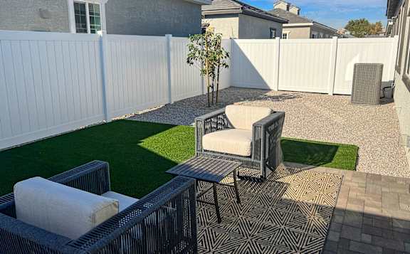 A private backyard at Zora Encanto  with a seating area and artificial grass