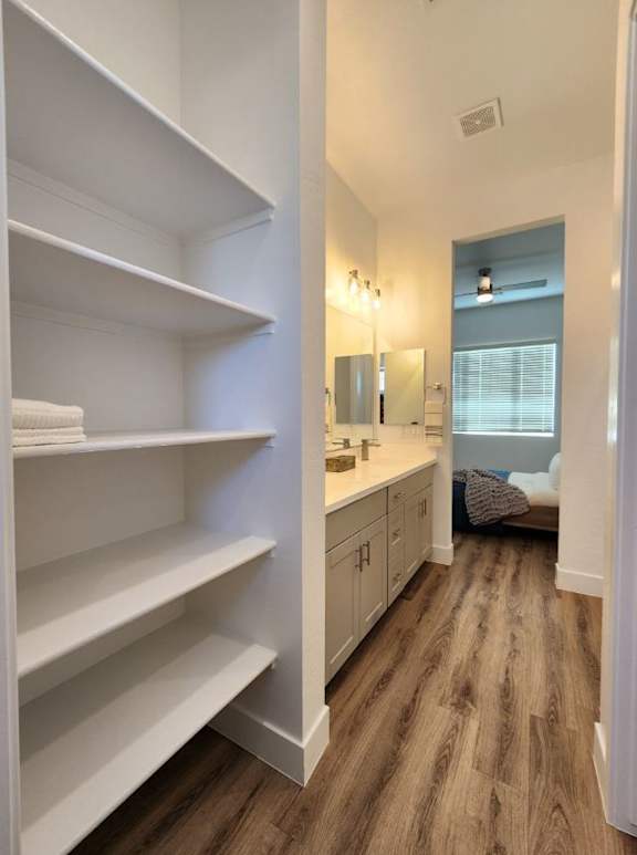 a bathroom at Zora Encanto apartments in Phoenix with shelves and a sink and a mirror