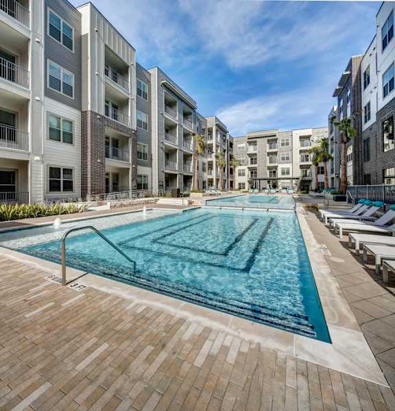 A large swimming pool in the middle of a courtyard surrounded by apartment buildings at Arise Riverside Apartments, Austin, 78741