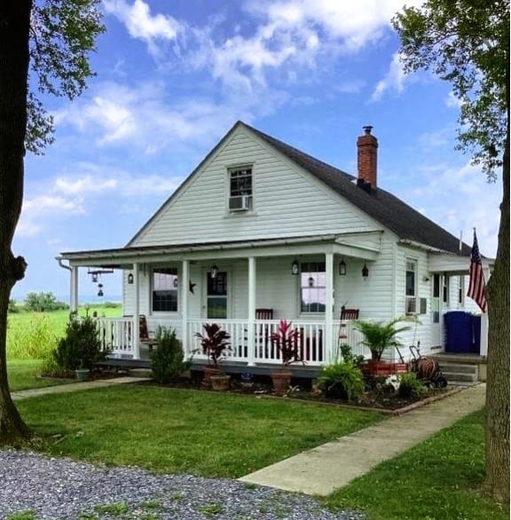 a white house with a porch and a lawn