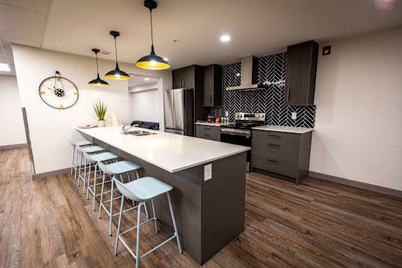 a modern kitchen with a large island and bar stools