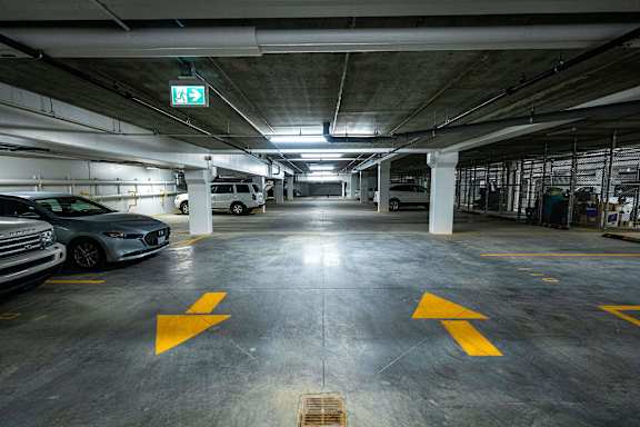 a parking garage with cars and a exit sign