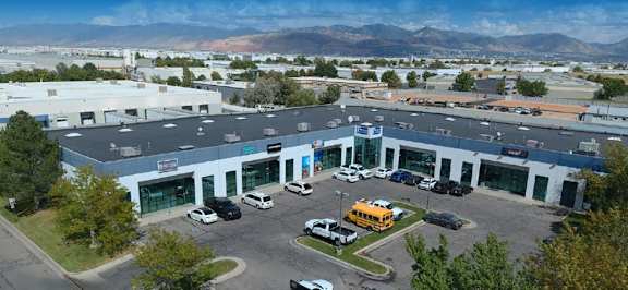 A parking lot with a yellow school bus and cars.