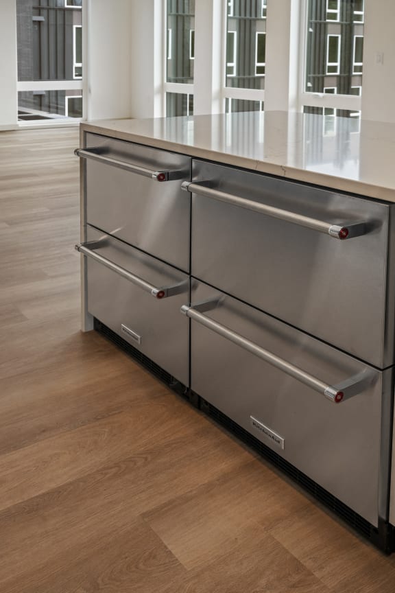 a stainless steel kitchen island with three drawers