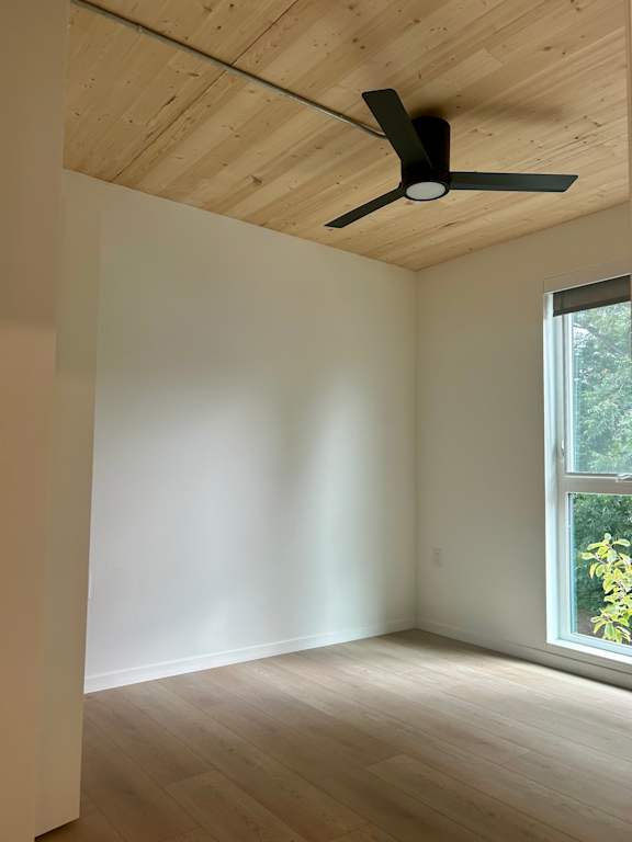 A room with a ceiling fan and a window.