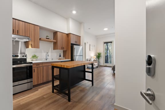 an open kitchen and living room with a large island with a wooden table