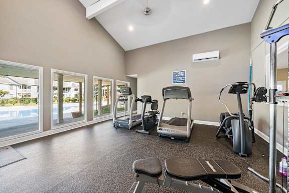 A gym with treadmills, exercise bikes, and other equipment.