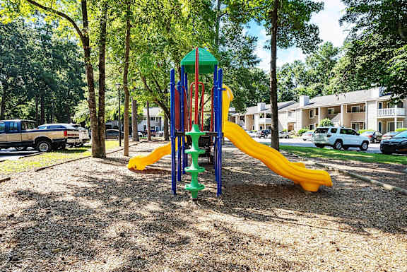 A playground with a yellow slide and a green top.